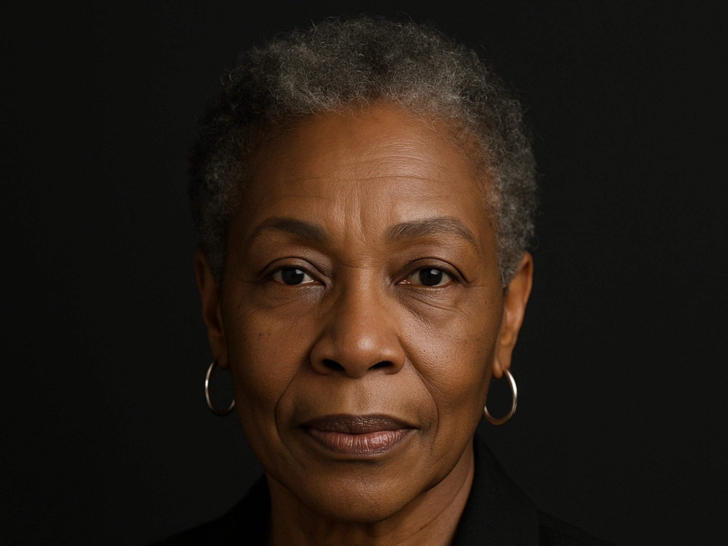 Portrait of an elderly woman with gray hair against a black background