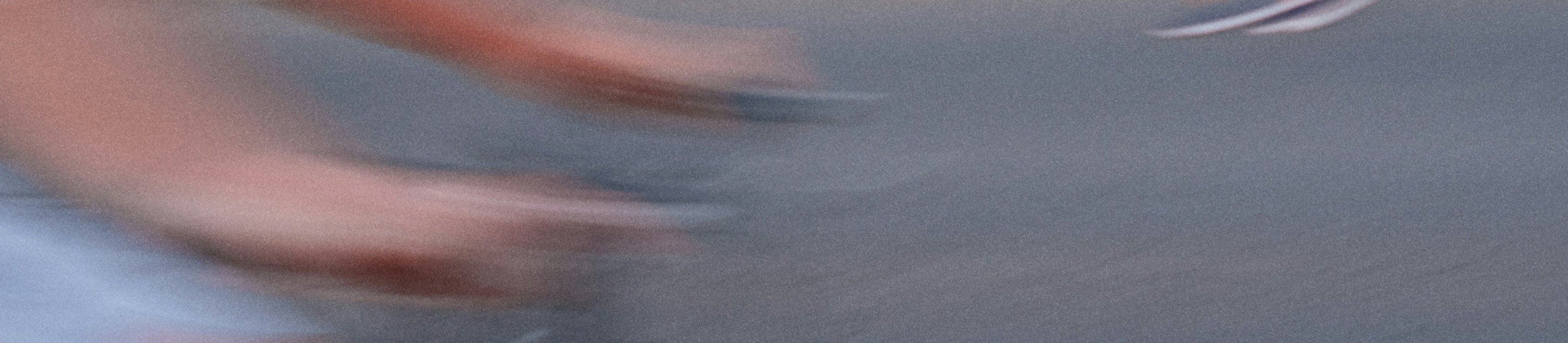 Blurry image of a person's hand on a bike handle, on a textured surface